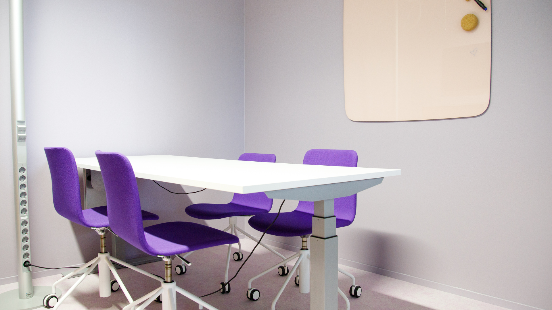Tässä kuvassa on Meitan toimiston neuvotteluhuone, jossa on pöytä, neljä tuolia sekä tussitaulu seinällä