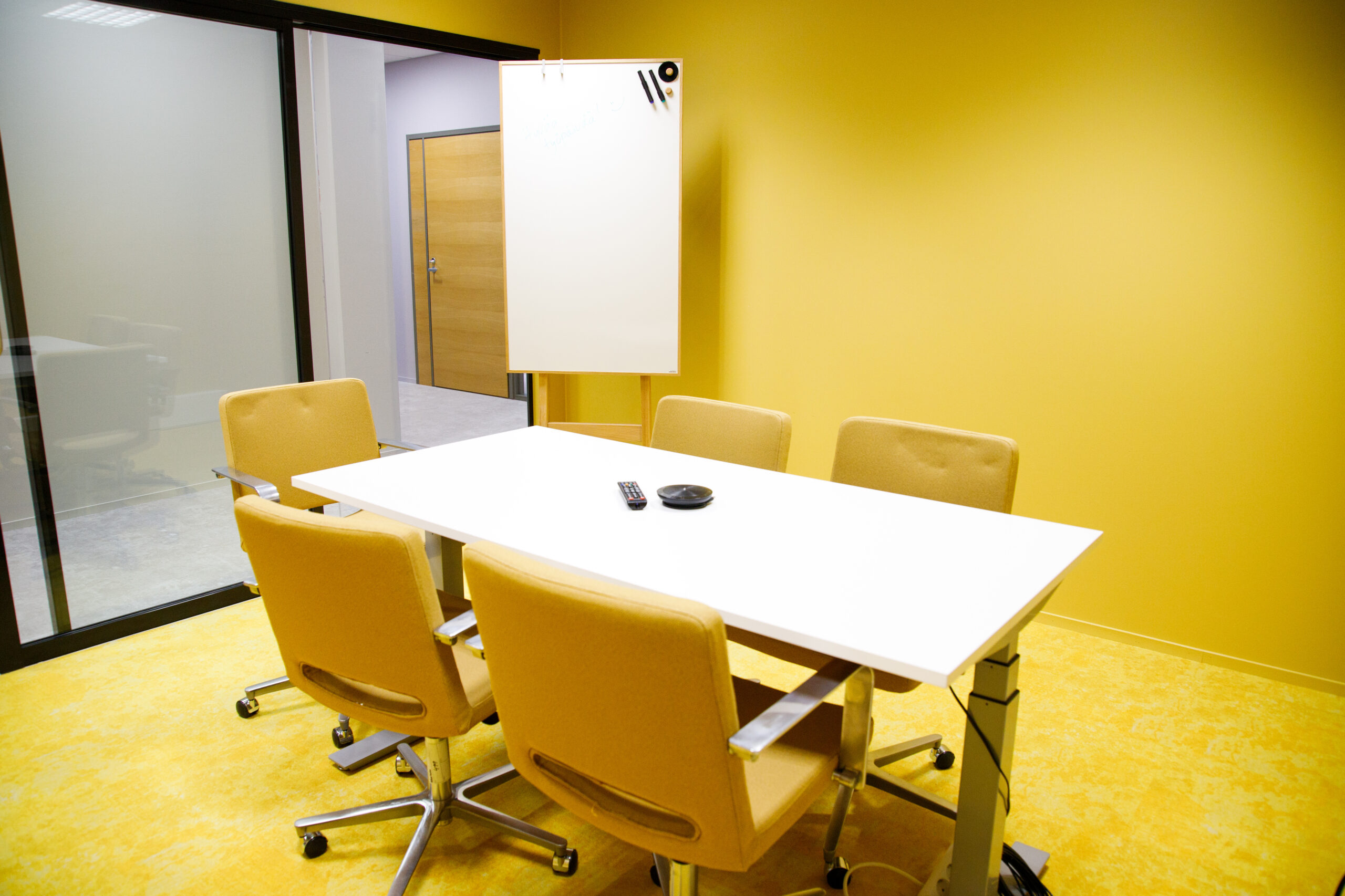 Tässä kuvassa on yksi Meitan toimiston neuvotteluhuoneista, jossa on pöytä, viisi tuolia sekä tussitaulu
